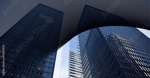 Digital composite image of abstract black geometrical shapes against tall buildings in background