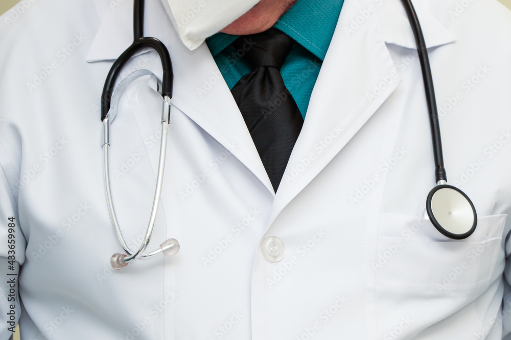 Medical stethoscope on the professional's neck over the lab coat, without showing the professional's face Medical stethoscope on the professional's neck over the lab coat, without showing the professional's face