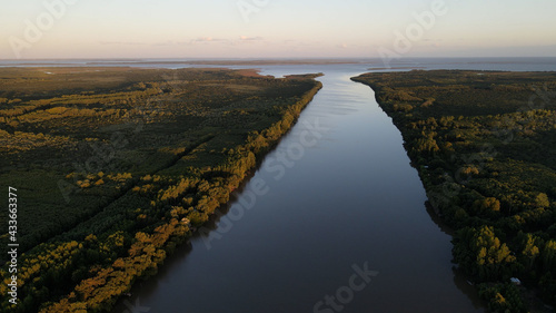 Aerial high shot of long Amazon River at sunset with large rainforest at the sides