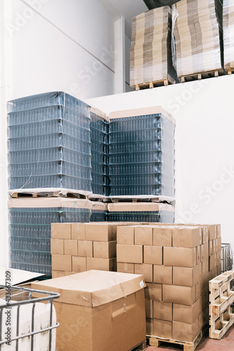 Warehouse with heaps of carton boxes and plastic containers with bottles of beer in factory photo