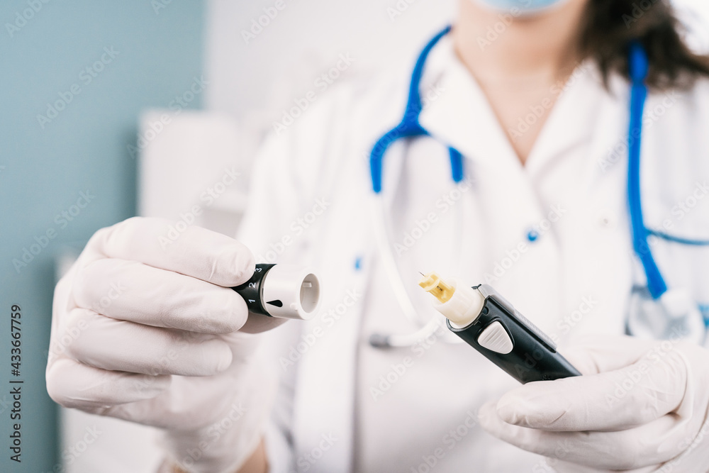 Crop unrecognizable female nurse in sterile gloves with blood sampling device at work in hospital Crop unrecognizable female nurse in sterile gloves with blood sampling device at work in hospital