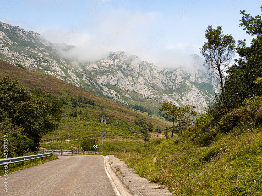 Vistas de la carretera solitaria rodeada de naturaleza verde y montañas, mientras viajamos por el Collado Joz en Cantabria, España, verano de 2020. 