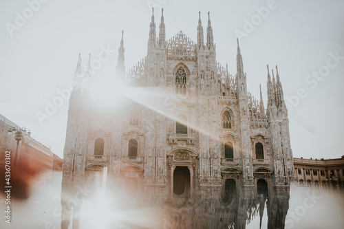 Old masonry church exterior with ornament between buildings under shiny sky in Milan Italy