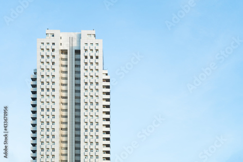 Front view of a white modern skyscraper perfect symmetry with blue sky and copy space. Architecture background concept