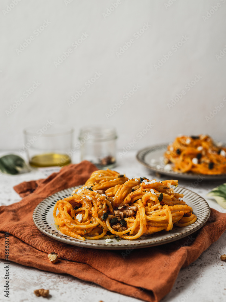 From above of delicious pumpkin noodles with seeds served on plate of table for lunch From above of delicious pumpkin noodles with seeds served on plate of table for lunch