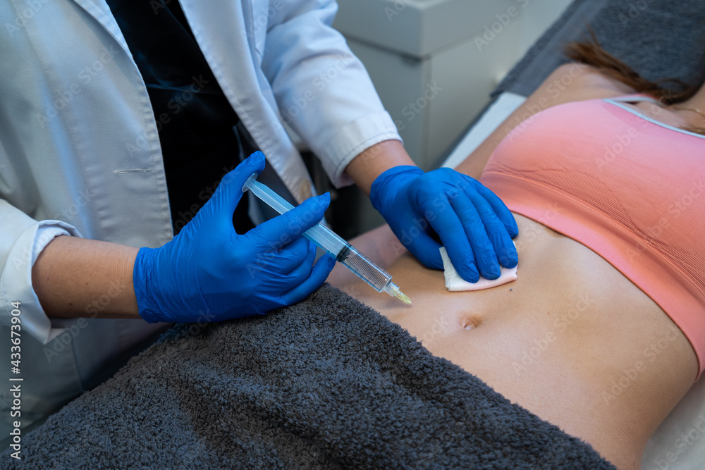 © Enrique Espinosa/ADDICTIVE STOCK - From above of crop anonymous professional beautician making injection for woman during cellulite treatment in beauty clinic
