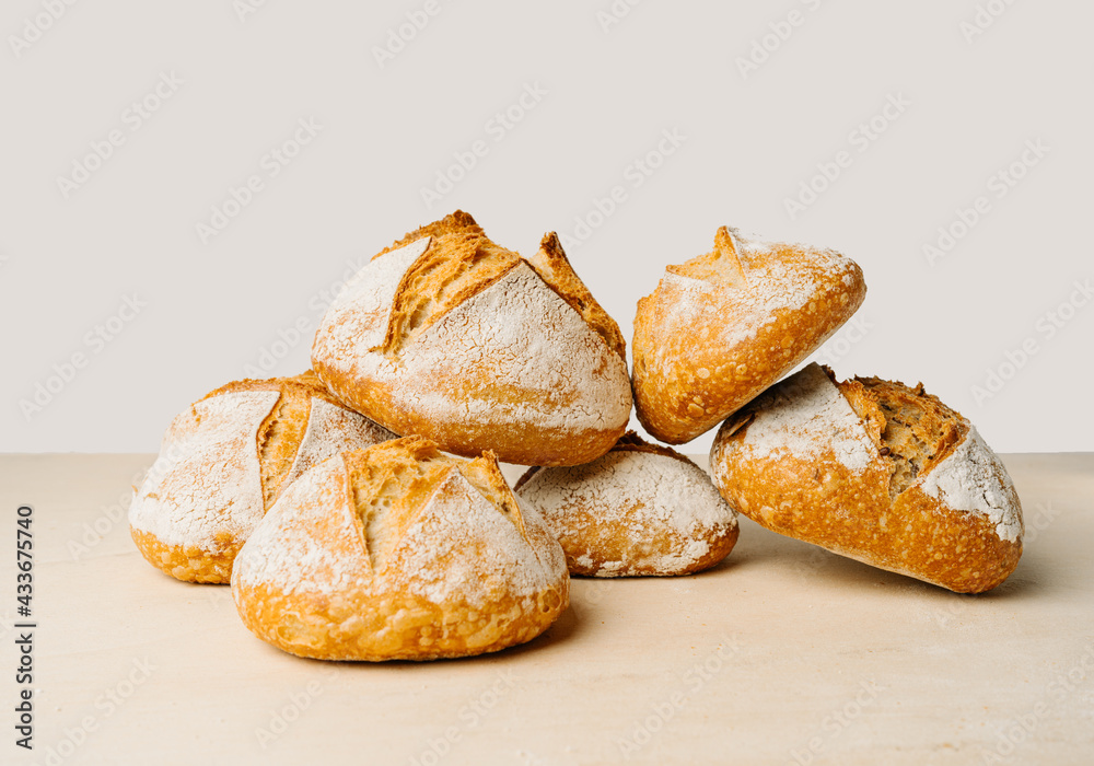 Delicious round shaped bread with flour on golden surface in bakery on white background Delicious round shaped bread with flour on golden surface in bakery on white background