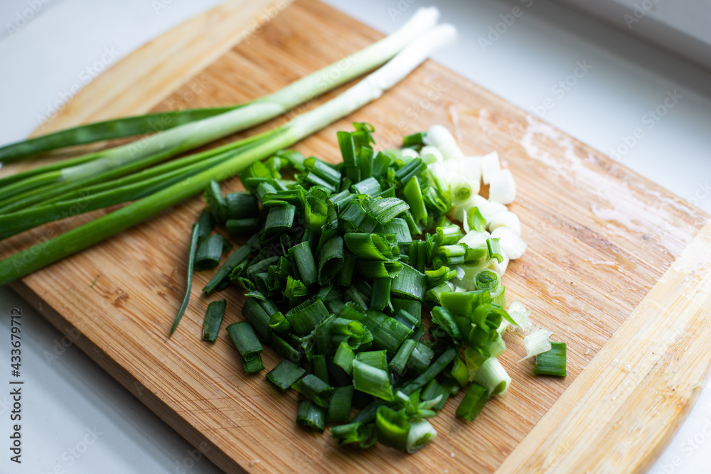 Young onion sliced and stands on a wooden board Young onion sliced and stands on a wooden board