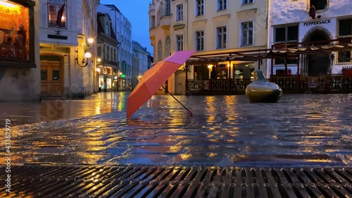 Rainy city light under  pink umprella on wet pavement under rain cily night light blurred light reflection lamp medieval house in Rainy Tallinn old town travel to Estonia ,Europe photo