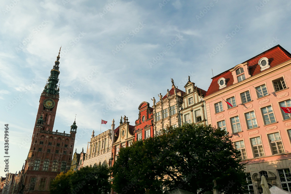 A close up of the facades of tall building in the middle of Old Town in Gdansk, Poland. The buildings have many bright colors, they are richly decorated. High tower of Town Hall. City tour. Clear day. A close up of the facades of tall building in the middle of Old Town in Gdansk, Poland. The buildings have many bright colors, they are richly decorated. High tower of Town Hall. City tour. Clear day.