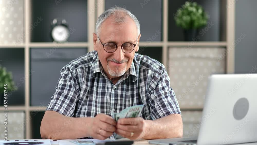 Happy elderly 70s man counting cash money dollar enjoying financial independence lottery win Happy elderly 70s man counting cash money dollar enjoying financial independence lottery win