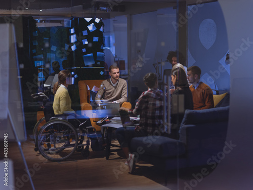 Businesswoman in wheelchair having business meeting with team at modern office 