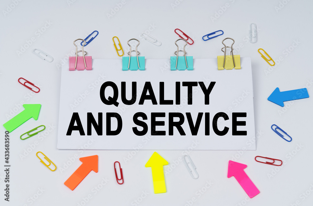 On the table there are paper clips and directional arrows, a sign that says - Quality and Service On the table there are paper clips and directional arrows, a sign that says - Quality and Service