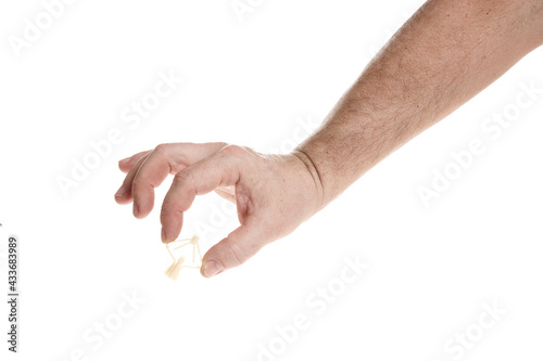 Hand holds a plastic dowel for screws on a white background
