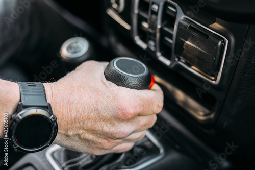 Crop view of anonymous man with her hand on the gear shift of an off-road car photo