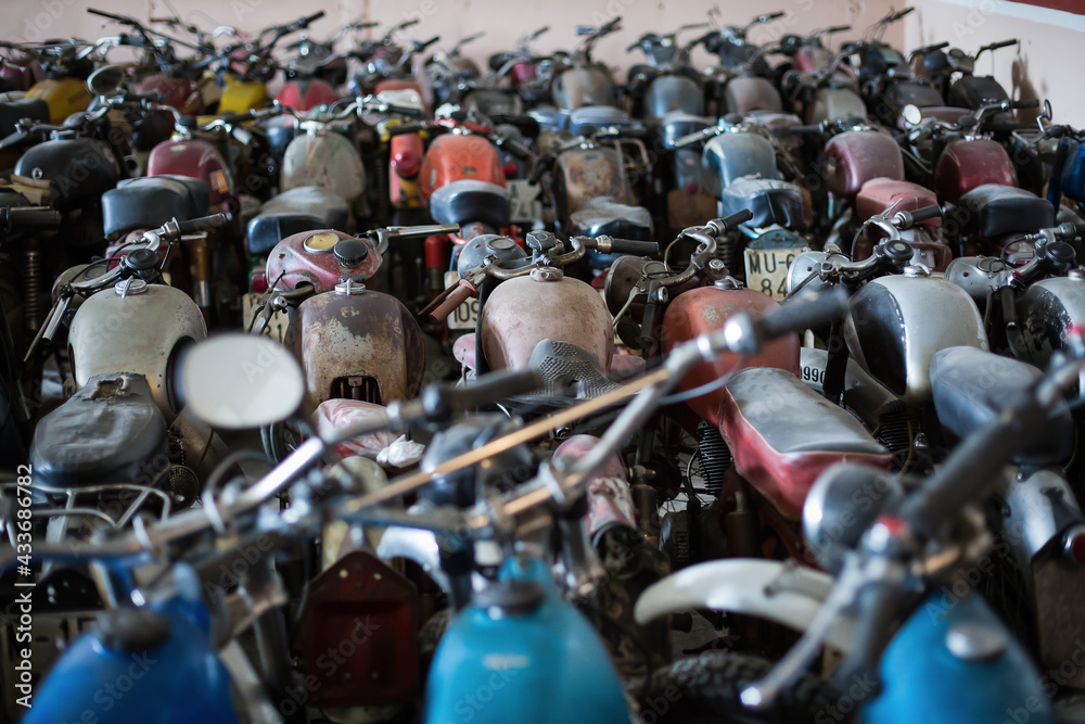 Many old fashioned damaged rusty motorcycles placed in rows in repair service workshop Many old fashioned damaged rusty motorcycles placed in rows in repair service workshop