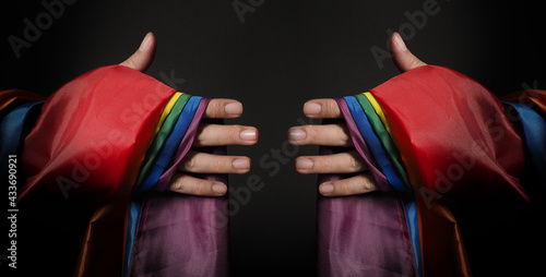 LGBTQ pride flag. Lesbian Gay Bi sexsual Transgender Queer. Homosexsual pride Rainbow flag in gay hand. black background. Represent symbol of freedom, peace, equality and love. LGBTQ concept. 
