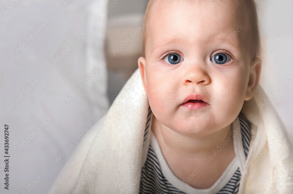 Close up portrait 9 month old baby with white towel. Teething, bathing, healthy sleep toddler.
Close up portrait 9 month old baby with white towel. Teething, bathing, healthy sleep toddler.