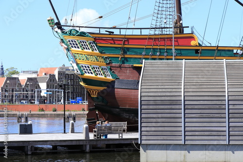 Amsterdam Oosterdok View with Old VOC Ship Replica and People Sitting on a Bench photo