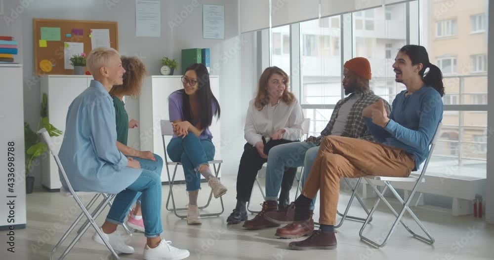Diverse people talking and helping each other in therapy session or support group meeting