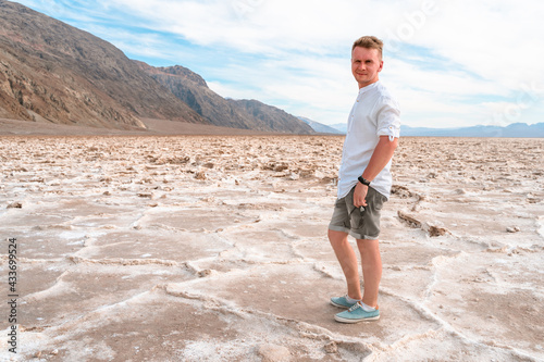 A young blond man visits a dried up salt lake A pool of bad water in Death Valley © KseniaJoyg