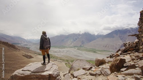 A man looking at the Panj river from Yamchun fortress in Wakhan valley, Tajikistan photo