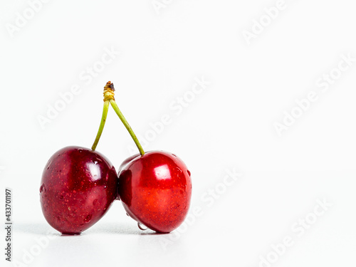 Macrophotograpy of two cherries on white background and copy space.  photo