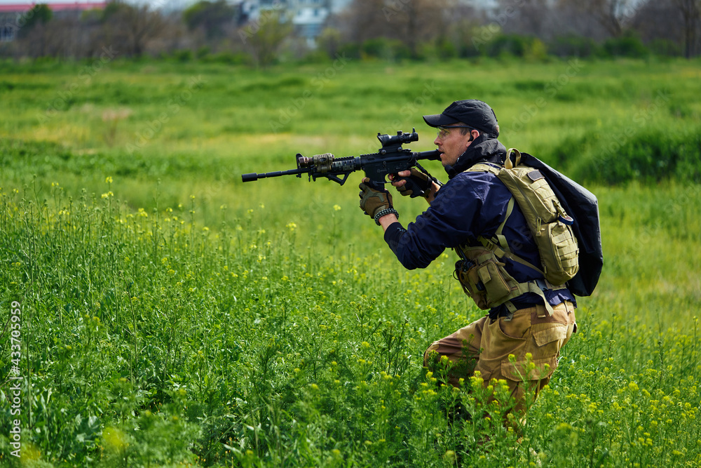 Airsoft player in military uniform holds a weapon in his hands Airsoft player in military uniform holds a weapon in his hands
