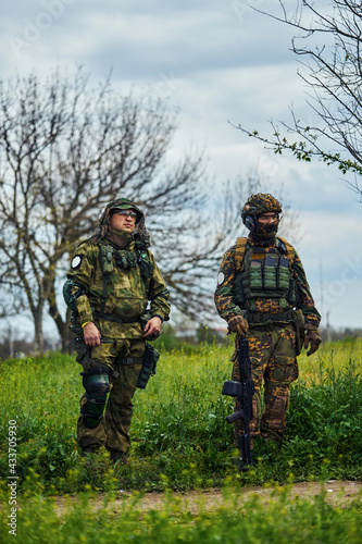 Two soldiers in outfit with weapons in the field