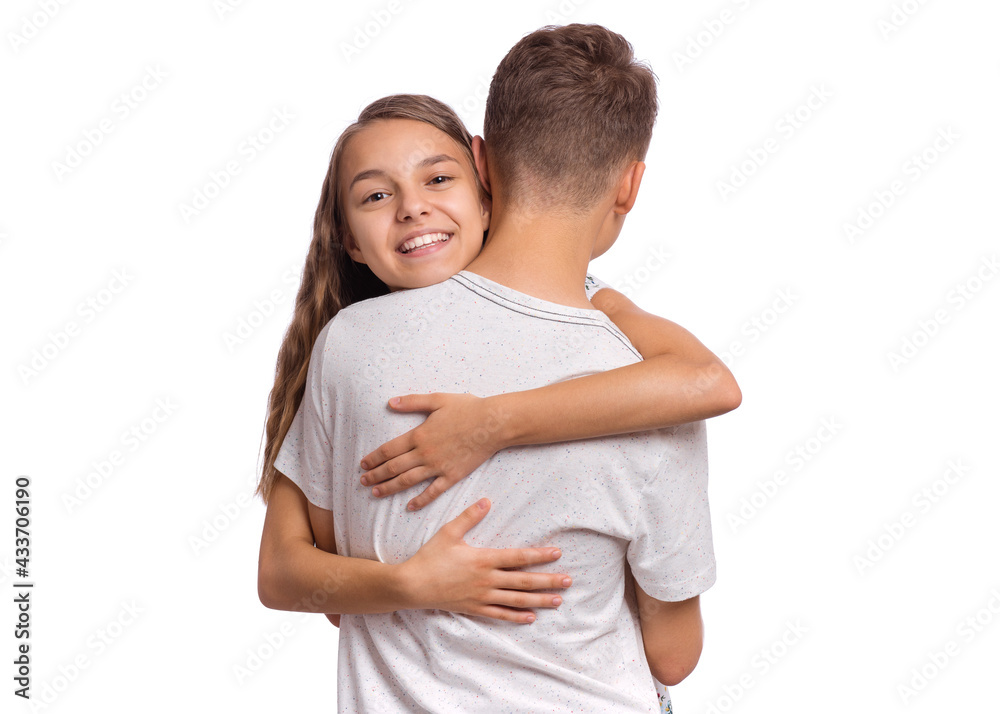 Happy teenagers standing together and hugging, isolated on white background. Sweet young couple in love. Teen girl smiling and hugging her boyfriend. Concept about love, people and lifestyle Happy teenagers standing together and hugging, isolated on white background. Sweet young couple in love. Teen girl smiling and hugging her boyfriend. Concept about love, people and lifestyle