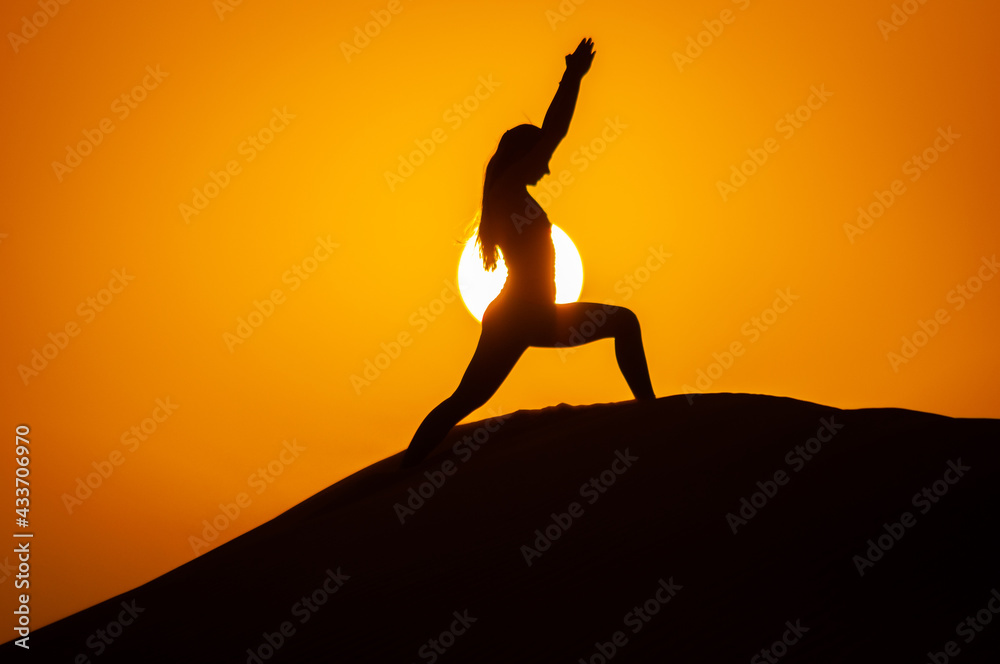 Silhouette of a young woman doing yoga pose at sunset Silhouette of a young woman doing yoga pose at sunset