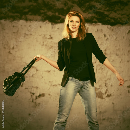 Young fashion blonde business woman in black blazer with handbag