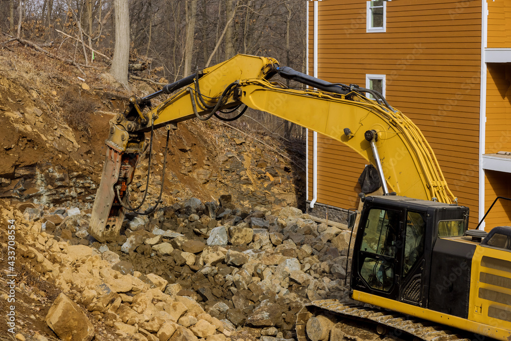Fototapeta premium Tractor for crushing large stones in a during earthmoving works at construction site at mountain