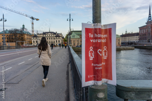 A signs on the lamppost in the central Stockholm with reminder about keeping distace photo