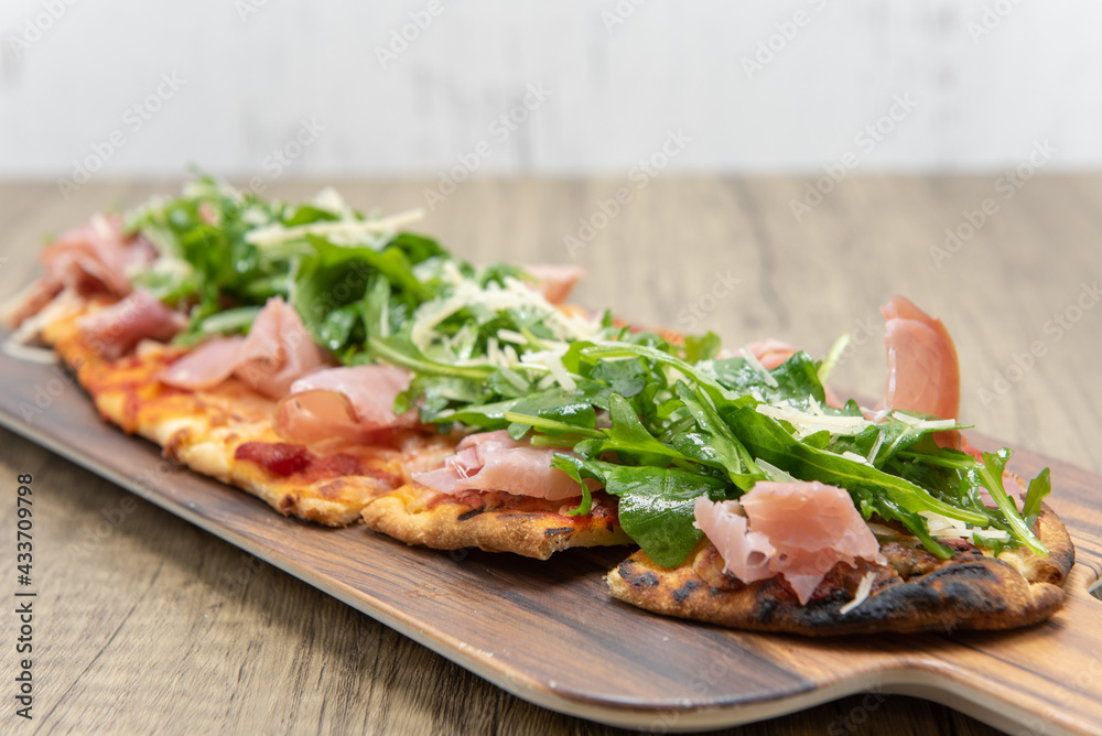 Delicious arugula prosciutto flatbread looks a lot like pizza but with long shaped crust