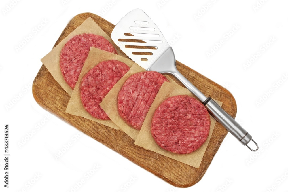 Minced Raw Steak Burgers from Beef Pork Meat on Cutting Board Isolated on White Background, Overhead View. Uncooked Ground Meat Patties for Grilling. Burgers for BBQ Grill and Spatula, Top View. Minced Raw Steak Burgers from Beef Pork Meat on Cutting Board Isolated on White Background, Overhead View. Uncooked Ground Meat Patties for Grilling. Burgers for BBQ Grill and Spatula, Top View.