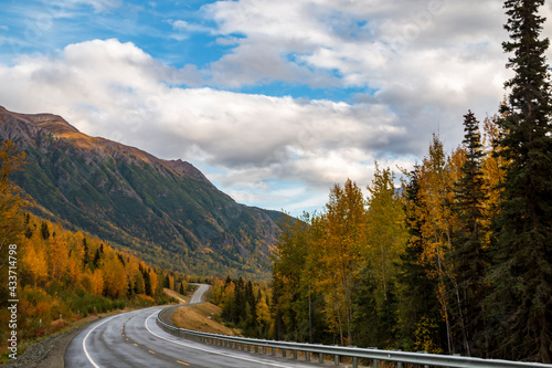 autumn road trip to the open roads of Alaska along the  snow capped mountains and vibrant golden yellow foliage of autumn. photo