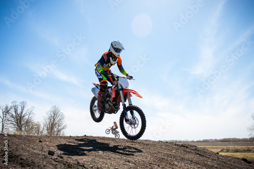 Motocross rider lands a jump on a race track.