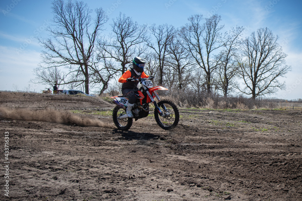 Dirt biker takes off spewing lots of dirt and debris.