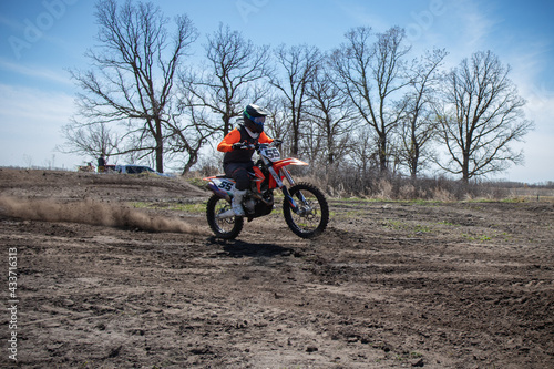 Dirt biker takes off spewing lots of dirt and debris.