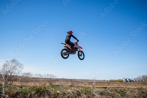 Motocross rider jumps his dirt bike on a racetrack. 