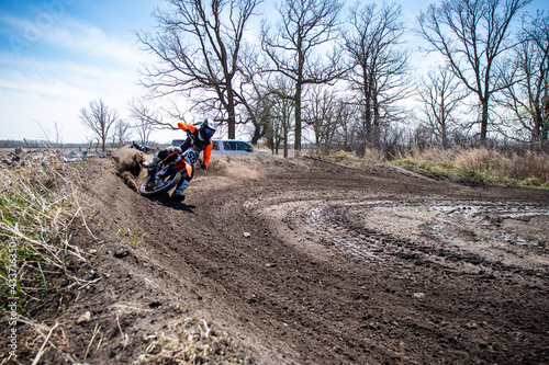 Motocross rider speeds through a corner with their foot out.