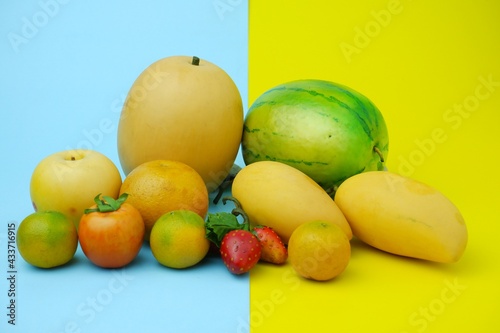 Fototapeta Naklejka Na Ścianę i Meble -  Plastic fruit on blue background with yellow color. Fake fruit, fruit model.
