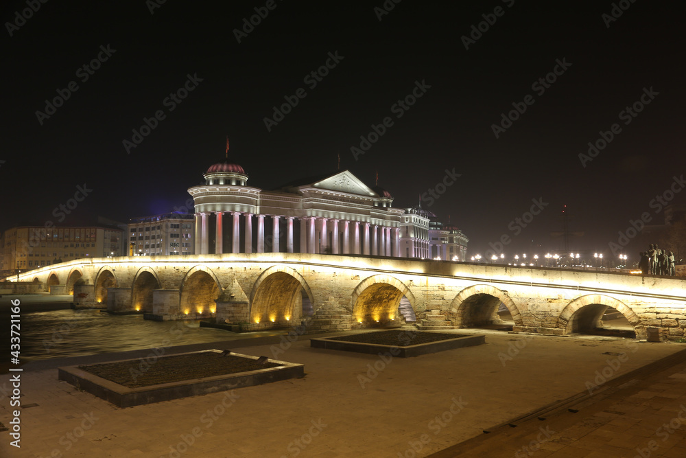 Fototapeta premium Stone Bridge, behind the Archeology Museum at night in Skopje, Macedonia. Stone Bridge is considered a symbol of Skopje.