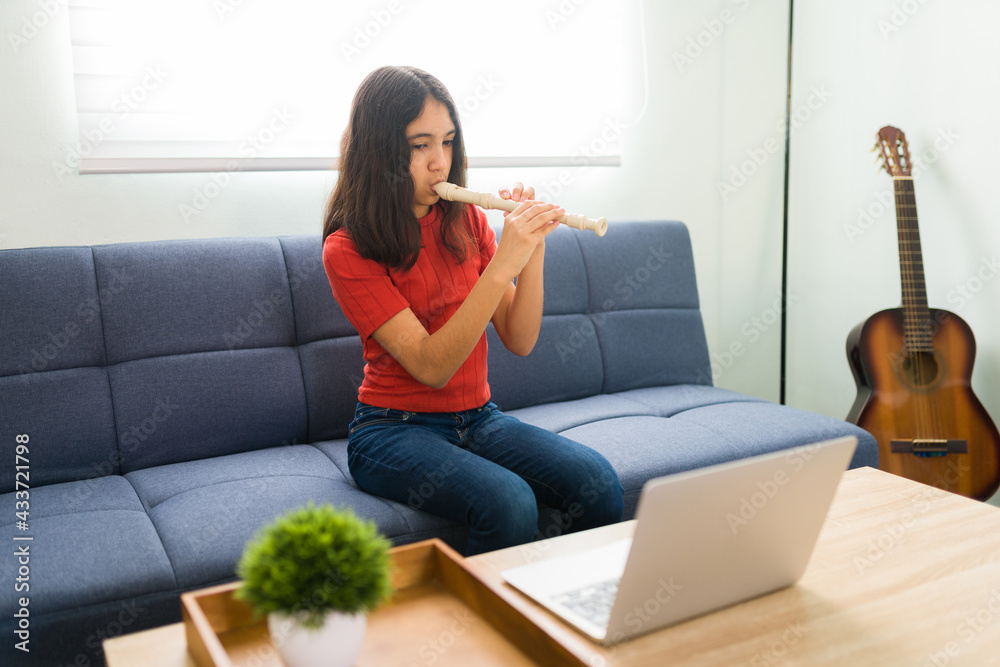 Preteen girl practicing for her music lessons Preteen girl practicing for her music lessons