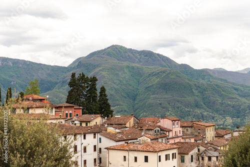 Old tiled roof. Beautiful roofs in the medieval town of Barga in Tuscany in the mountains of Italy. Beautiful mountains outside the city. Old houses are ledges. © Михаил Шаповалов