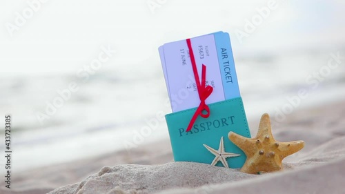 Plane tickets and passport on the beach near the sea close up