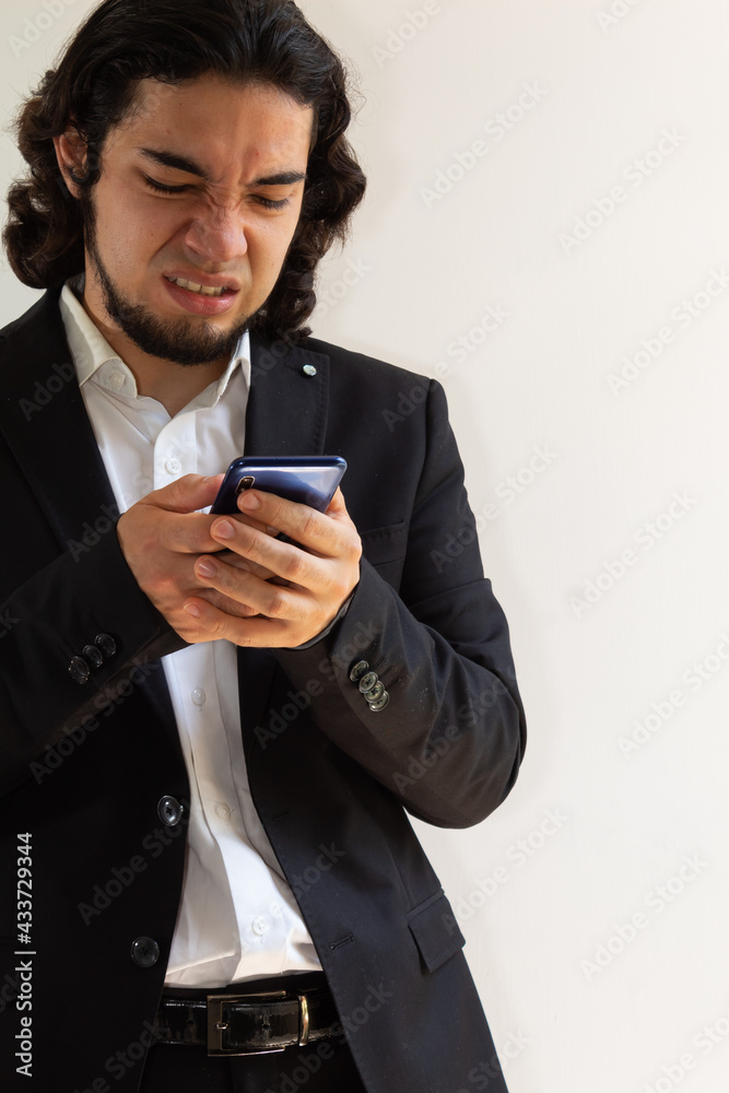 Hispanic man in black suit demonstrating a negative attitude on a white background Hispanic man in black suit demonstrating a negative attitude on a white background