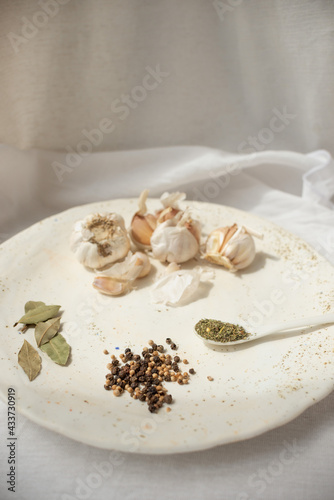 Wallpaper Mural Cooking seasoning set: garlic, bay leaf, pepper and herbs on a handmade ceramic plate. . High quality photo Torontodigital.ca