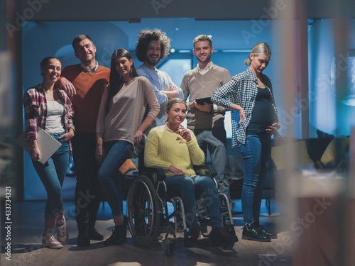 Disabled businesswoman in a wheelchair at the office with coworkers team